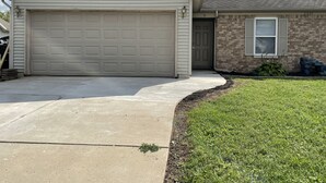 A single-story house with a garage, a brick exterior, and a well-maintained lawn. - Colorful home near Purdue! (Lafayette)