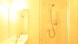 Un bagno con lavandino, specchio e doccia.