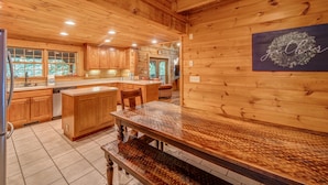 Ein Holzhütten-Interieur mit einer Küche, die Holzschränke, eine Granitabdeckung und eine Bank zeigt.