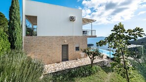 A modern two-story house with a stone facade, a balcony, and a pool. - Dreamviewvillas (ΛΕΥΚΑΔΑ)