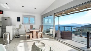 A modern kitchen with a dining area and a balcony with a scenic view. - Dreamviewvillas (ΛΕΥΚΑΔΑ)