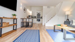 Un espace de vie moderne comprenant une cuisine, un coin repas et un escalier.