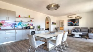 Eine moderne Küche mit Essbereich, Wohnzimmer und Flur.