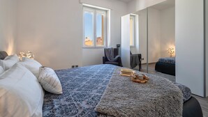 Ein Schlafzimmer mit Bett, Stuhl, Nachttisch und Fenster.