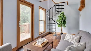 Un salon moderne avec un escalier à volutes, un canapé, une table basse et une plante en pot.