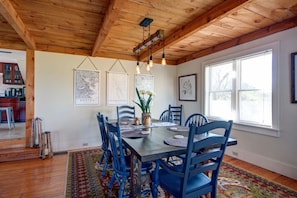 A dining area with a wooden ceiling, blue chairs, a wooden table, and framed artwork on the walls. - Pet friendly Skaneateles country home one mile from downtown!! (Skaneateles)