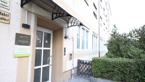 A building with a glass door entrance, a metal awning over the door, and signs for 'Luxomes' and 'Secco'. - LUXOMES - Aparthotel Zentrum (Nuremberg)