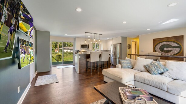 A modern living room with a sofa, coffee table, and a kitchen area in the background.
