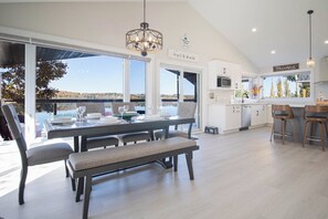 A modern kitchen with a dining area overlooking a scenic view.