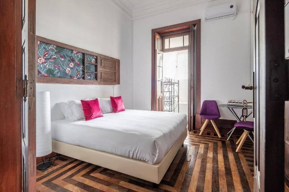 A bedroom with a bed, a desk, and a chair.