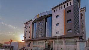 Un hotel moderno con una entrada destacada, varios pisos y una fachada singular.