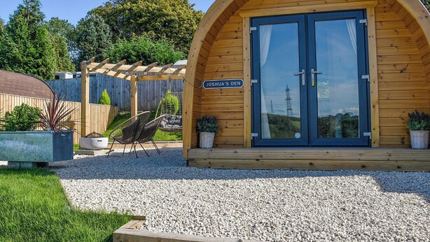 A wooden cabin with a sign reading "JOSHUA'S DEN". - Joshua's Den - UK40975 (Near Swansea)