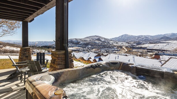 Un jacuzzi con vista a un paisaje nevado y montañas.