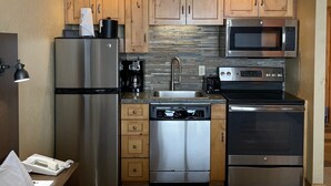 A compact hotel kitchen with a refrigerator, microwave, oven, and dishwasher. - The Grand Summit Hotel in the Canyons Village - Close to Golf - Pool, Gym, Spa, More! (Park City)