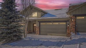 A residential house with a garage, a snow-covered driveway, and a large evergreen tree. - Private Hot Tub, Close to Resorts - Private Hot Tub - Close to PC, Mountain Mansion Family Getaway (Heber City)