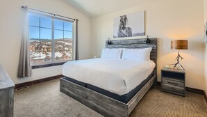 A bedroom with a large window, a bed, a nightstand, and a ceiling fan. - Private Hot Tub, Close to Resorts - Private Hot Tub - Close to PC, Mountain Mansion Family Getaway (Heber City)