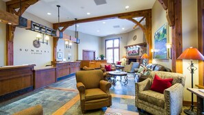 A lodge with a reception desk, seating area, and a fireplace.