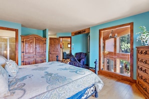 Une chambre avec un grand lit, une armoire en bois et une vue sur l’extérieur.