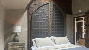 A bedroom with a bed, a nightstand, a lamp, and a wooden door. - Cabin Forest Retreat (Monte rio)