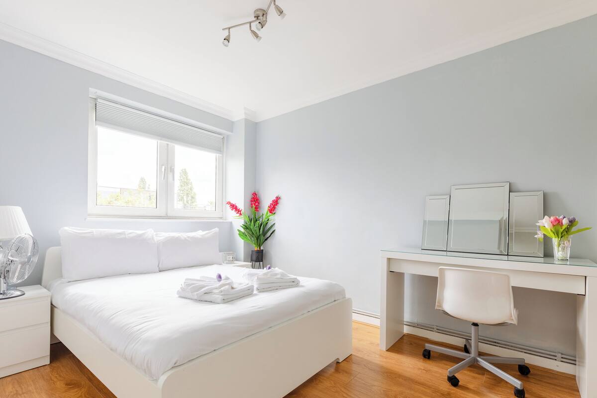 Une chambre à coucher moderne avec un grand lit, un bureau et une chaise.