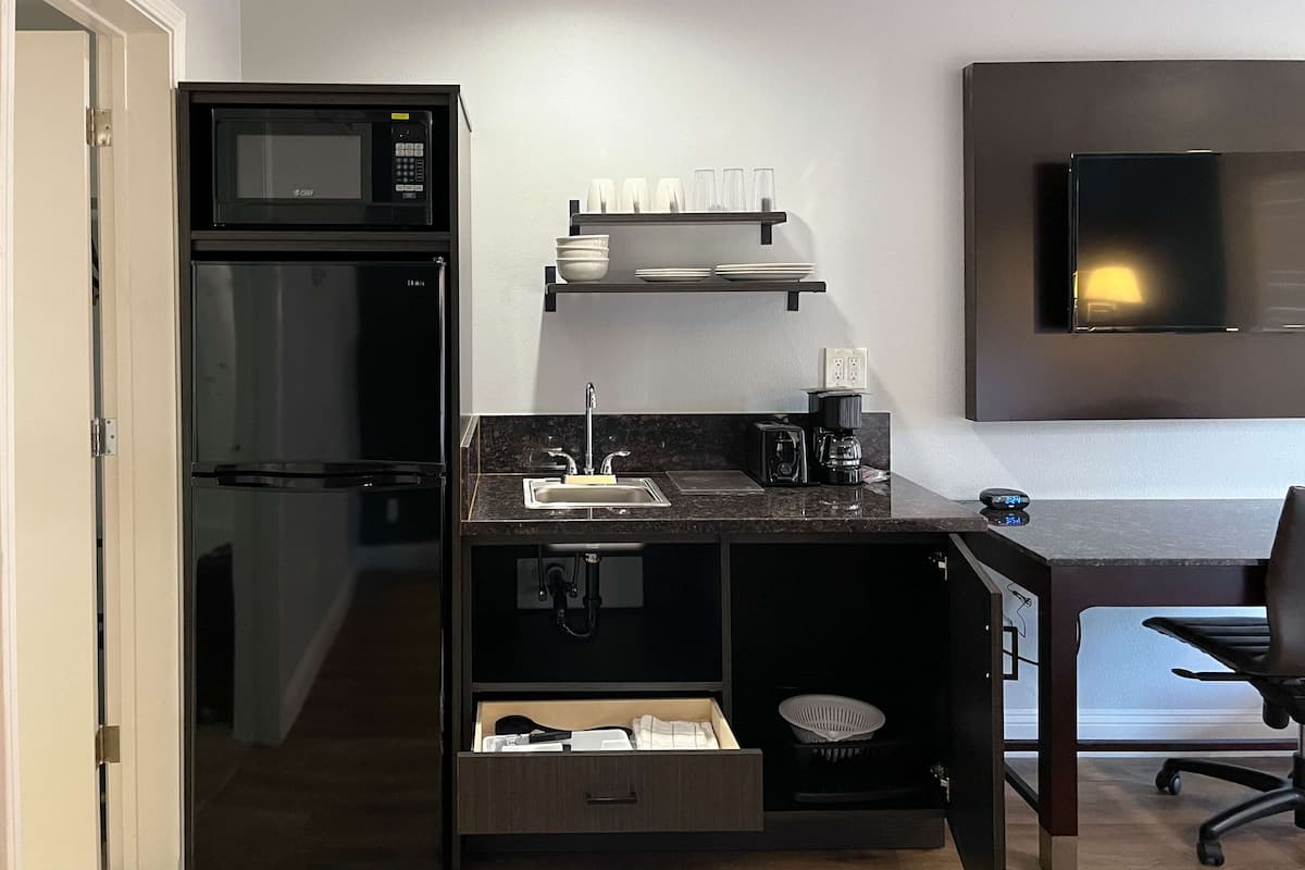 A compact kitchenette with a microwave, coffee maker, and a small sink.