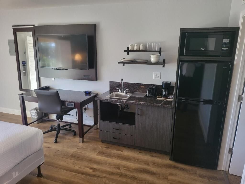 A compact kitchenette with a microwave, refrigerator, and a small countertop.