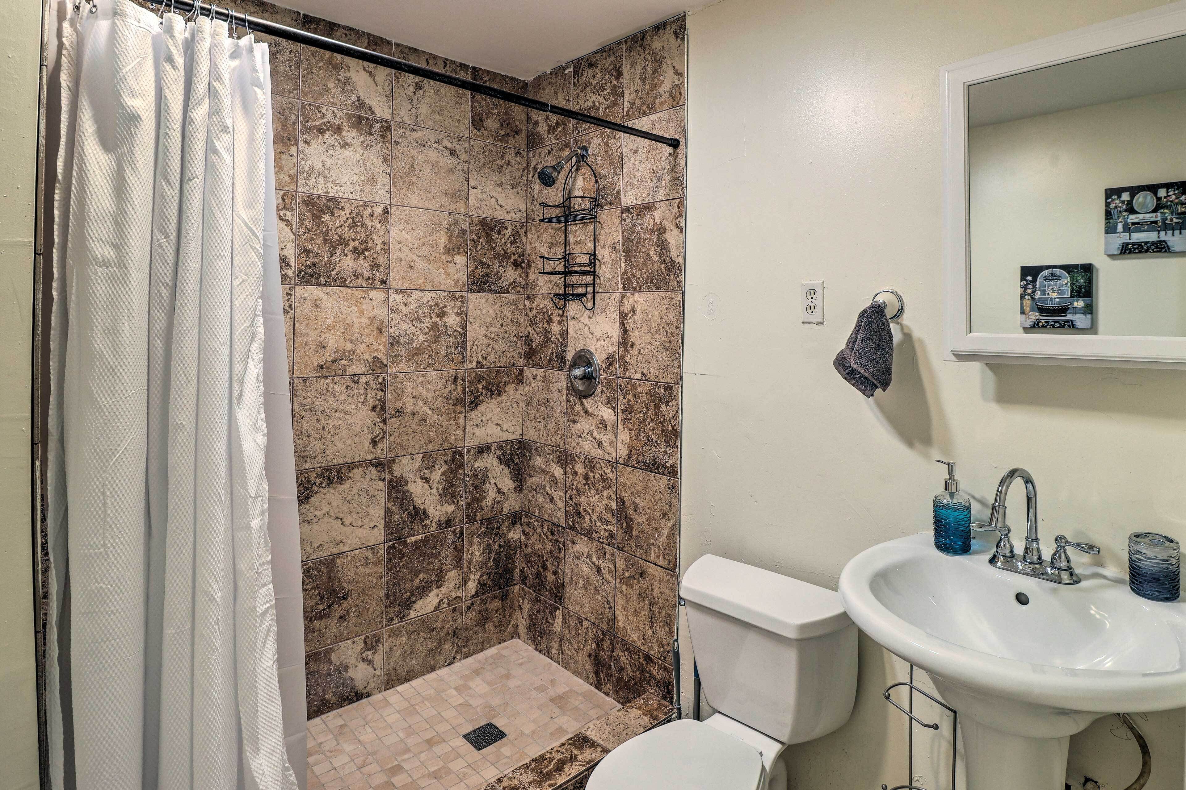 Ein Badezimmer mit Dusche, Toilette und Waschbecken.