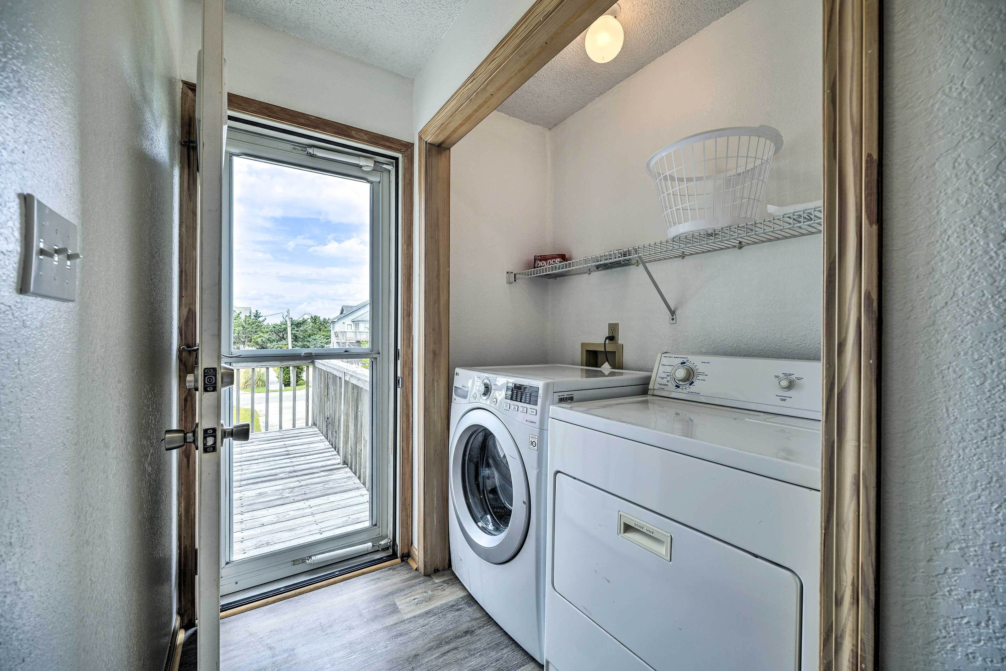 A laundry room with a washing machine, dryer, and a shelf with a basket.