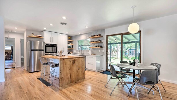 A modern kitchen with a central island, stainless steel appliances, and a dining area with a round table and chairs. - < 3 Mi to Pearl St: Home w/ Large Yard in Boulder (Boulder)