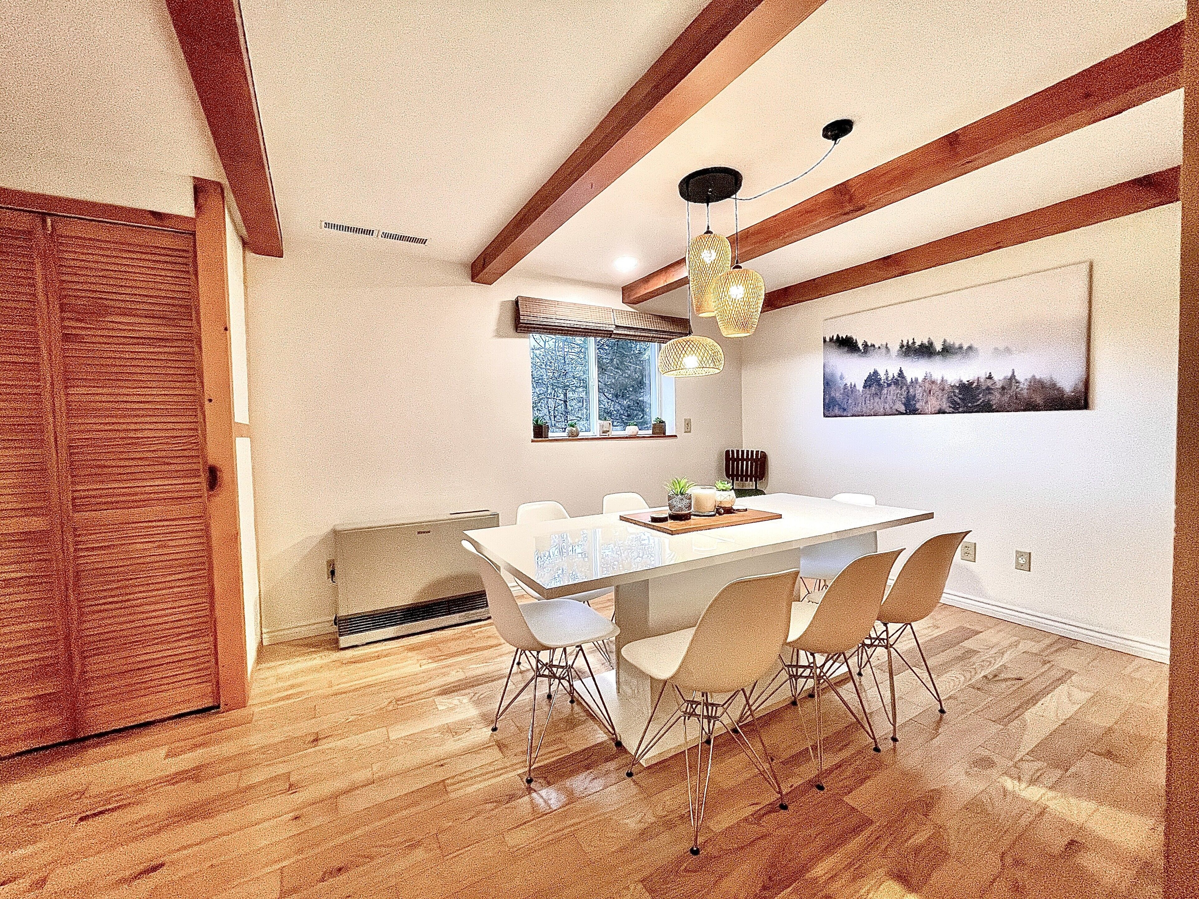 Un comedor moderno con techo de madera, una mesa grande y cuatro sillas.