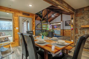 Enjoy meals in this cozy dining area with a wooden table and comfortable black leather chairs.