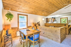 Relax in this rustic retreat with a dining table for two, a comfortable seating area, and a charming wooden chest.