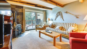 A cozy living room with a sofa, coffee table, and a fireplace. - Silverthorne Condo w/ Lake Views: 10 Mi to Skiing! (Silverthorne)