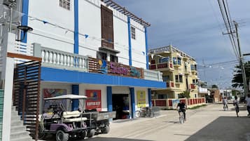 A hotel with a blue and white facade, a sign reading "Super Sky," and a Club Car parked in front.