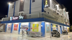 A multi-story building with a prominent 'Super Sky' sign on the ground floor, indicating a hotel or lodging establishment.