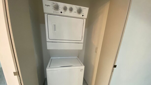 A compact washer and dryer unit in a small laundry room with a tiled floor. - Departamento en Marina del Sol con vista al mar (Mazatlán)