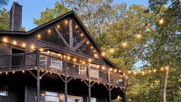 A wooden cabin with a deck, outdoor seating, and a fire pit. - STUNNING Mountain VIEW Lodge for 14! (Murphy)