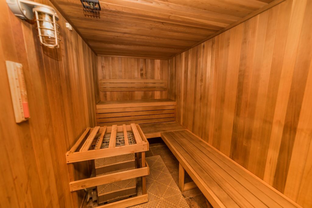 Una sauna de madera con bancos y un asiento de banco.