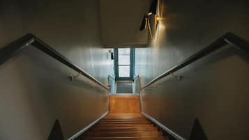 Eine hölzerne Treppe mit Metallgeländern, die zu einer Tür oben führt.