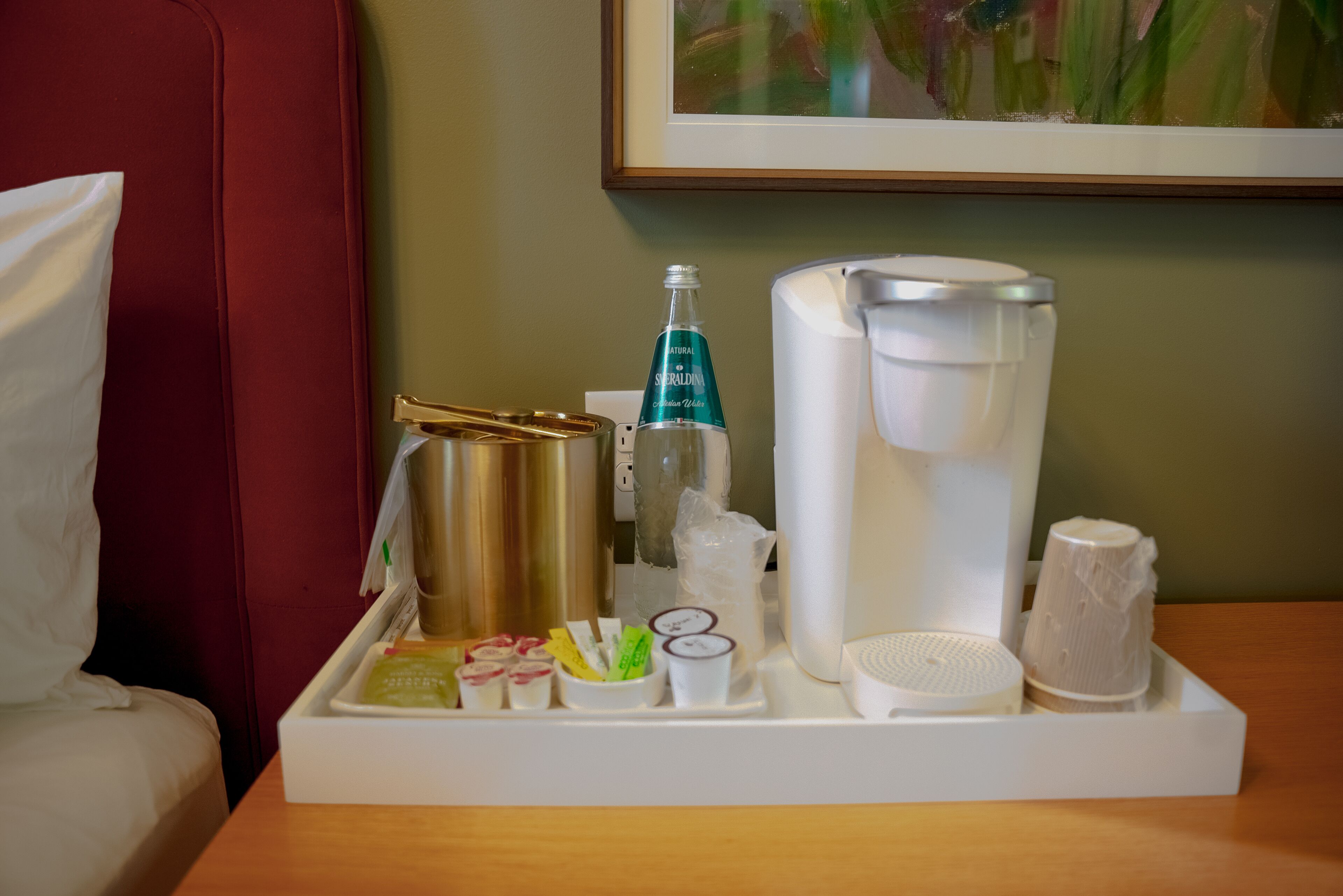 Un plateau contenant des articles de toilette, notamment un flacon de Sealdin, une machine à café et divers petits récipients.