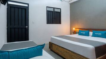 A bedroom with a large bed, a smaller bed, and a wardrobe. There is a window and a door.