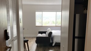 A bedroom with a bed, a window, and a door. - Stylish 1 Bedroom Apartment in Gadsden, AL (Gadsden)