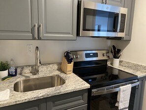 Enjoy cooking in this well-equipped kitchen with an oven, microwave, and stainless steel sink.