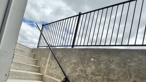 Una escalera de concreto con barandales de metal, que sube a un nivel superior.