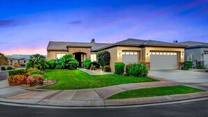 A modern two-story house with a well-maintained lawn, a driveway, and a garage.