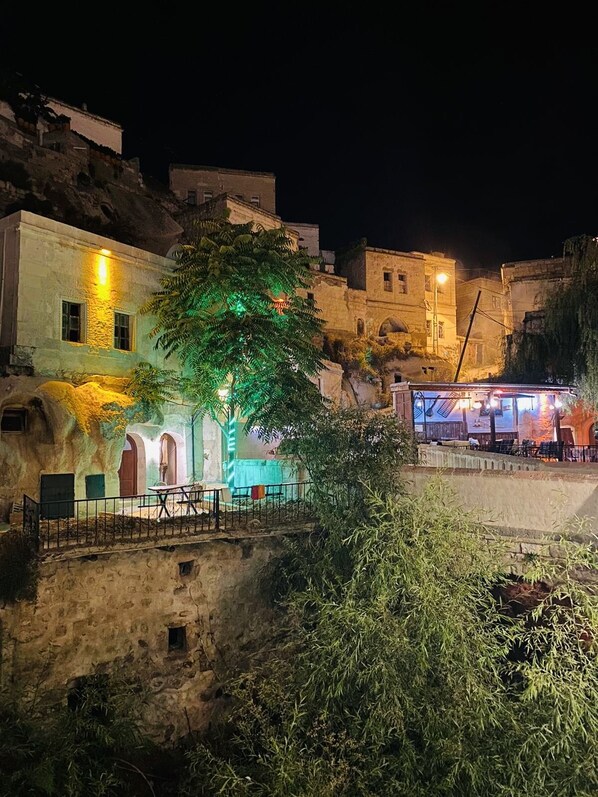 A nighttime view of a historic building with stone walls and a tree in the foreground. - Ela cave house (Ürgüp)