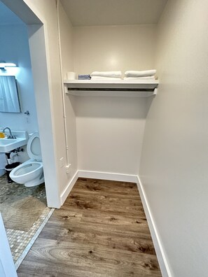 A small bathroom with a toilet, sink, and a shelf above the toilet. - Sophisticated Studio Apartment in Gadsden, AL (Gadsden)