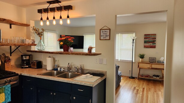 A modern kitchen with a central island, stainless steel appliances, and a wooden countertop. - Cozy Comfy (Bourbonnais)