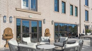 An outdoor patio with wicker furniture, a round table, and a fountain.