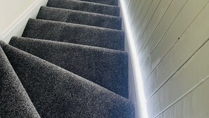 A staircase with carpeted steps leading to a door with a window above it. - 3 Bedrooms Apartment With Free Parking, Self Check in/out - Perfect for 8 Guests (Cowdenbeath)